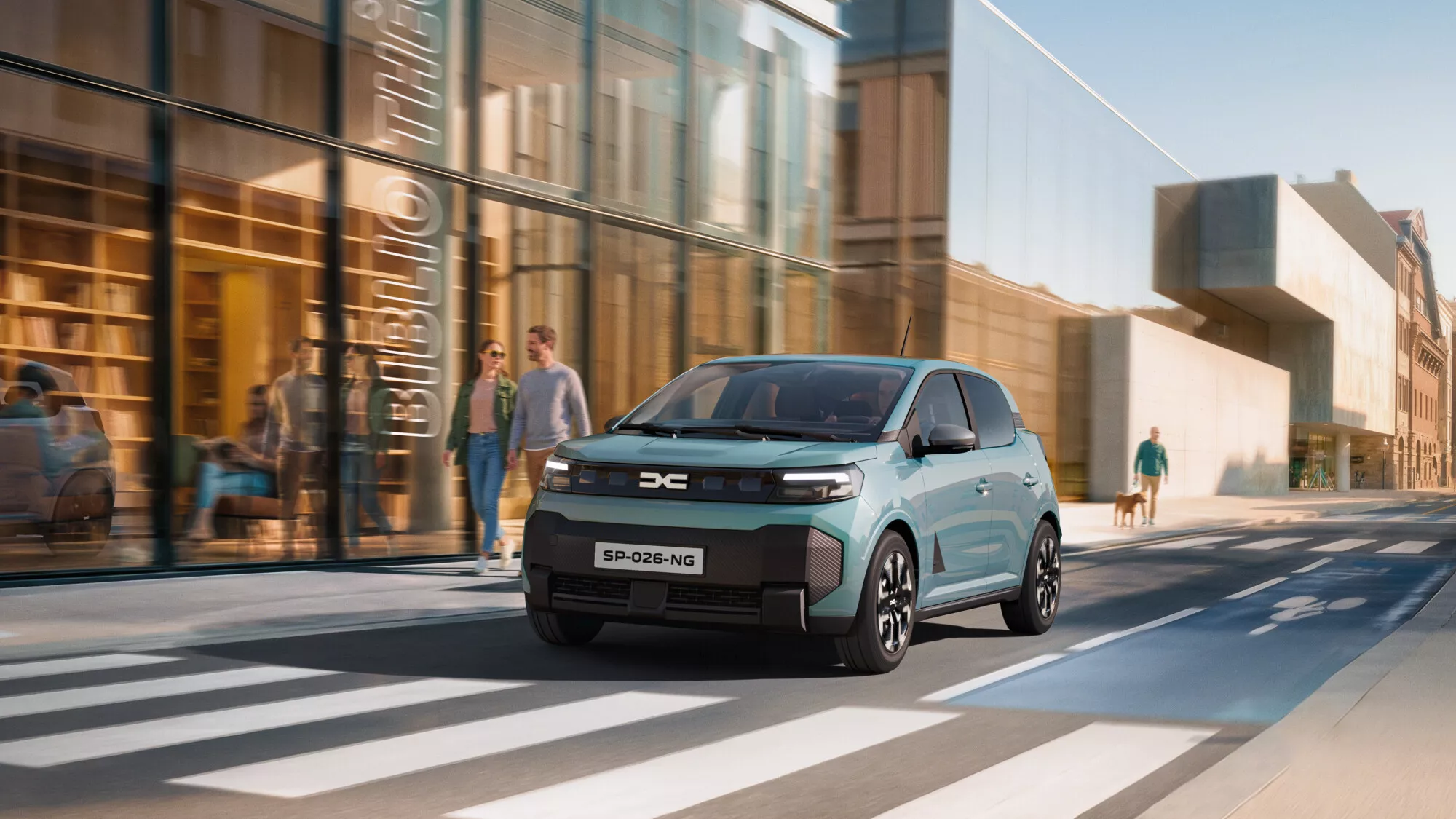 La nouvelle Dacia Spring électrique de couleur vert d'eau roulant en ville