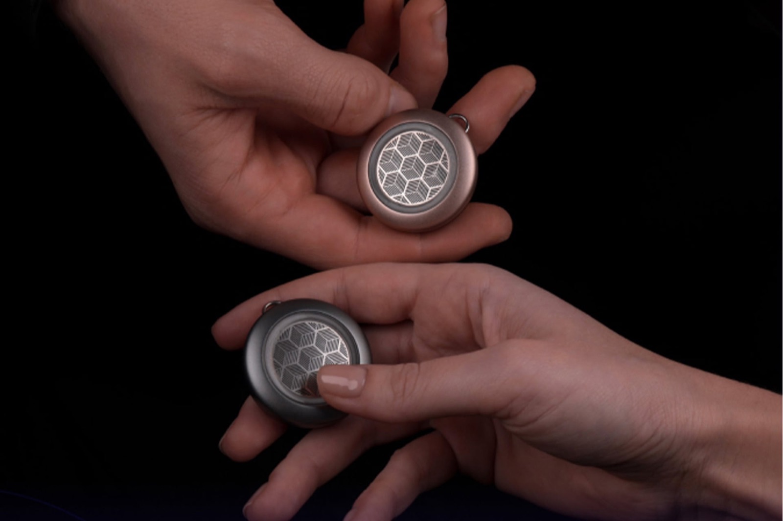 Le porte-clés connecté EthyloKey d'Ethylowheel tenu dans deux mains, en finitions cuivre et gris
