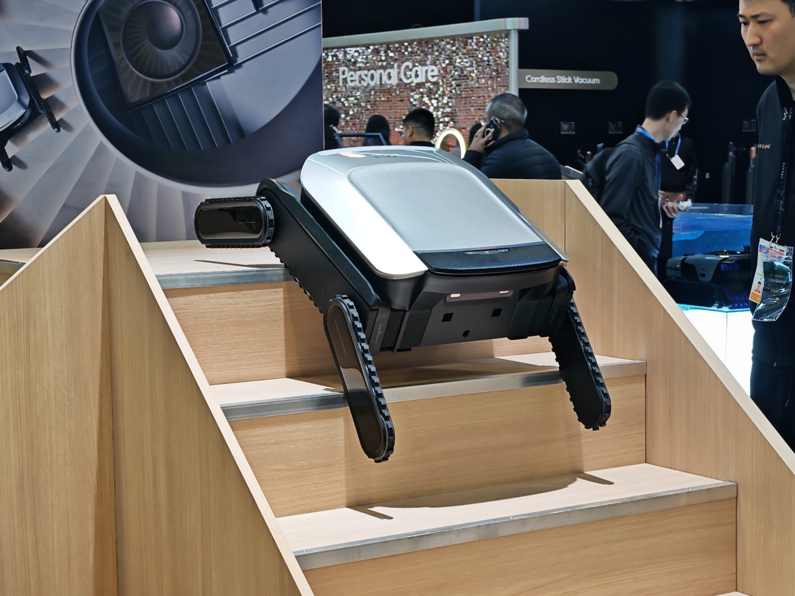 Le robot Dreame Cyber X gravissant un escalier sur ses chenilles lors d'un salon