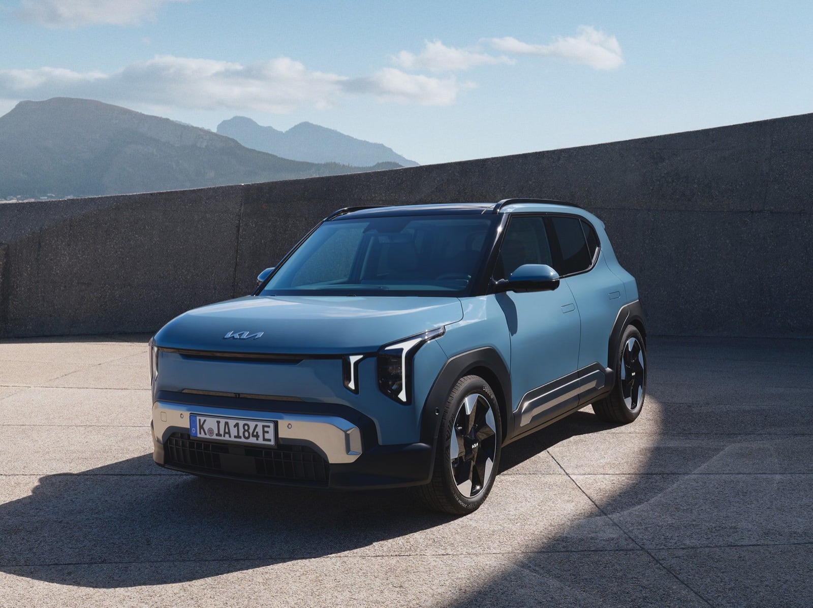 Kia EV2, petit SUV électrique bleu-gris vu de trois quarts avant, garé en extérieur