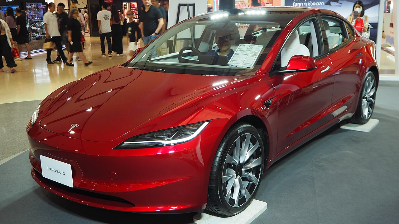 Une Tesla Model 3 rouge exposée en concession
