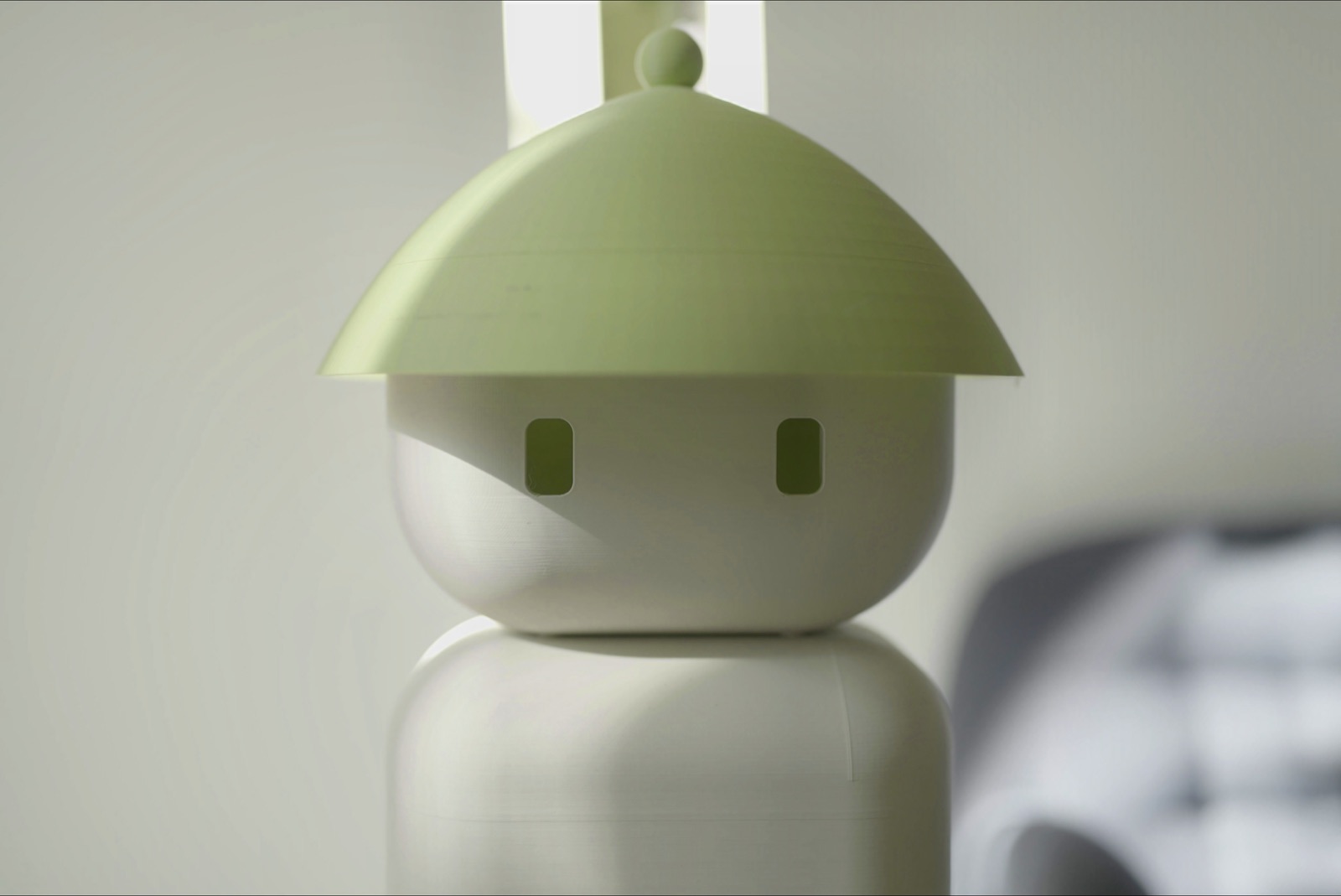 Gros plan sur la tête blanche et verte du robot domestique Flourish 1