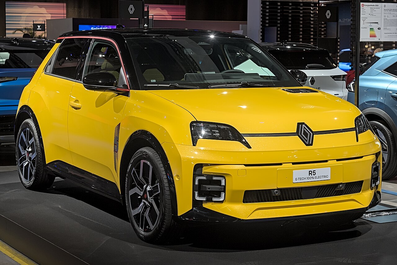 Renault 5 E-Tech 100% électrique de couleur jaune, vue de trois quarts avant sur un stand