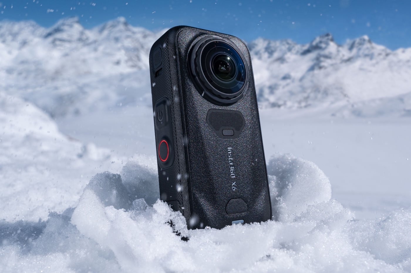 La caméra 360 Insta360 X6 posée dans la neige devant un décor de montagnes enneigées