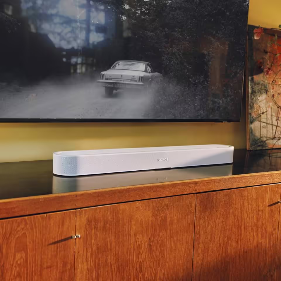 La barre de son Sonos Beam Ultra blanche posee sous un televiseur