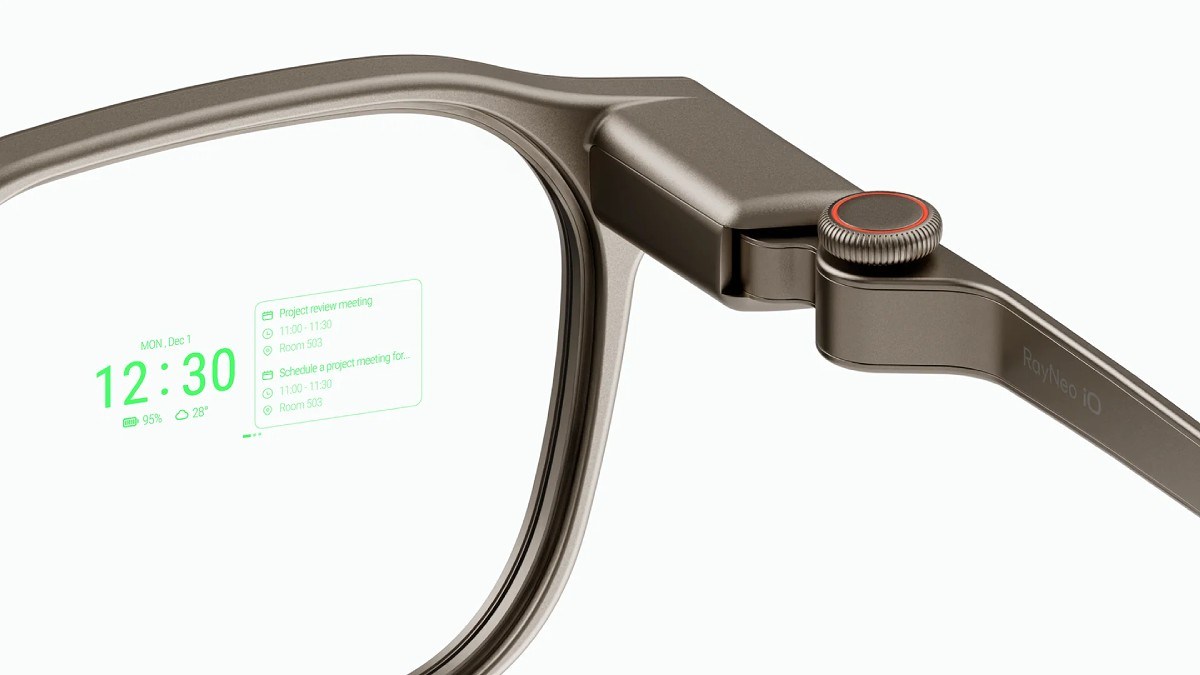 Gros plan sur les lunettes connectées RayNeo iO avec leur affichage vert monochrome (heure, agenda, météo) et la molette Smart Crown