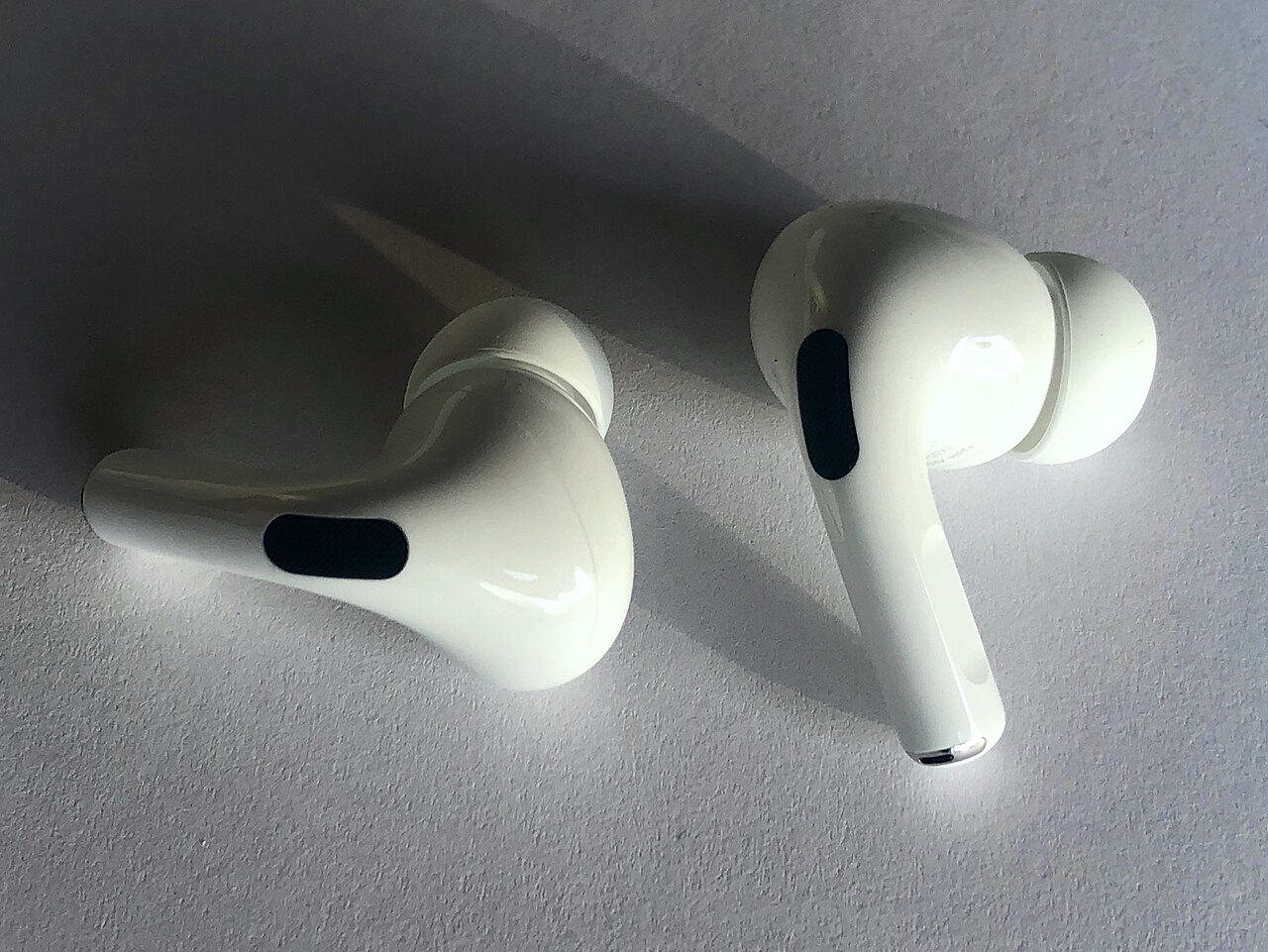 Deux écouteurs AirPods Pro d'Apple posés sur une surface claire