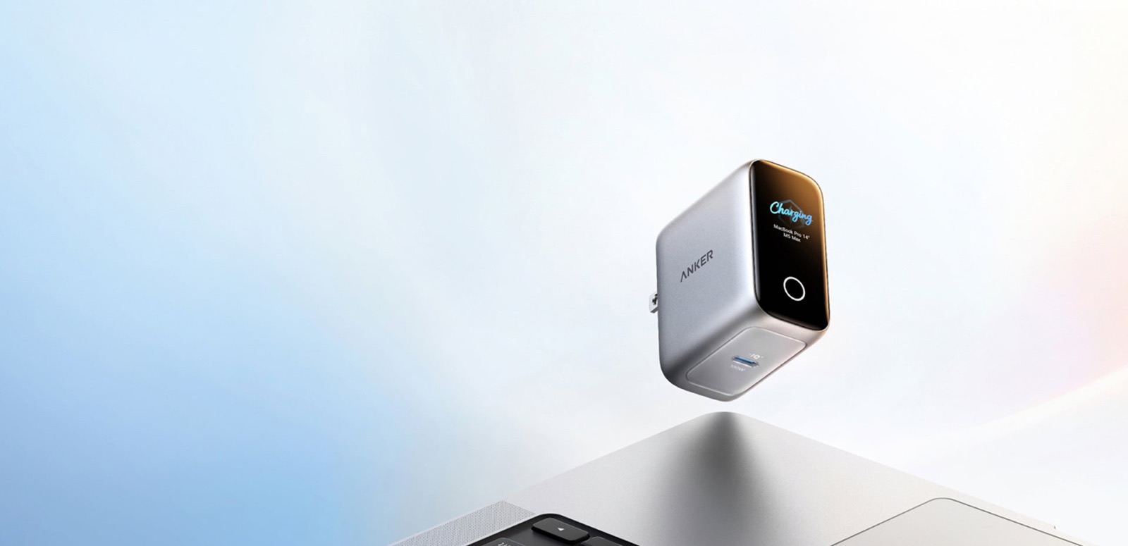 Chargeur Anker Laptop Charger Pro avec son petit écran affichant la charge, au-dessus d'un MacBook