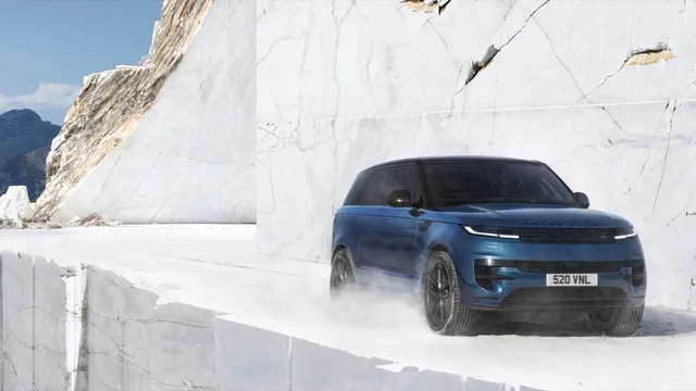 Range Rover Sport electrique bleu en vue trois quarts avant dans une carriere de marbre blanc
