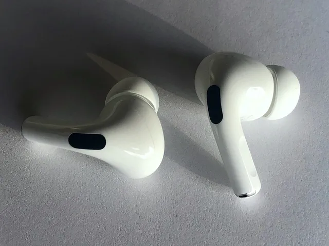 Deux écouteurs AirPods Pro d'Apple posés sur une surface claire