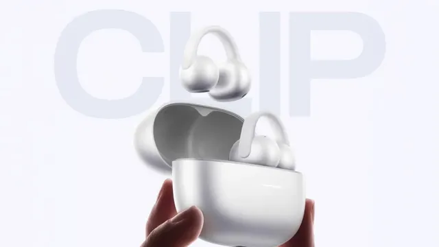 Écouteurs à clip REDMI Clip Neo blancs et leur boîtier de recharge tenu à la main