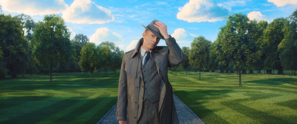 Paul Bettany dans le rôle de Vision, en trench et costume, sur une allée de parc, image promotionnelle de la série Disney+ VisionQuest